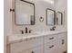 Bright bathroom featuring double sinks with white cabinets, black hardware, and large rectangular mirrors at 2448 Ram Crossing Way, Henderson, NV 89074