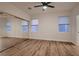 Spacious bedroom with hardwood floors, mirrored closet doors, and large windows with blinds at 2448 Ram Crossing Way, Henderson, NV 89074