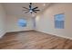 Large bedroom with hardwood floors, arched windows, a ceiling fan, and neutral colored walls at 2448 Ram Crossing Way, Henderson, NV 89074