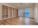 Spacious room with hardwood floors, built in bookshelves, and access to private patio through sliding glass doors at 2448 Ram Crossing Way, Henderson, NV 89074