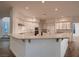 Kitchen with white cabinets, countertop seating, and stainless steel appliances at 2448 Ram Crossing Way, Henderson, NV 89074