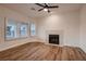 Cozy living room featuring hardwood floors, neutral paint, a fireplace with mantel and large windows with views at 2448 Ram Crossing Way, Henderson, NV 89074