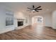 Spacious living room with wood floors, a fireplace, modern lighting and window shutters at 2448 Ram Crossing Way, Henderson, NV 89074