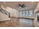Spacious living room with wood floors, large windows, modern ceiling fan, and staircase at 2448 Ram Crossing Way, Henderson, NV 89074