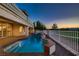 Beautiful in-ground pool with a stone patio, wrought iron fence, and lush green landscaping at 2448 Ram Crossing Way, Henderson, NV 89074