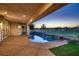 Covered patio with an inground pool and spa overlooking a green landscape with fencing at 2448 Ram Crossing Way, Henderson, NV 89074