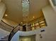 A winding staircase is illuminated by a dazzling chandelier at 2448 Ram Crossing Way, Henderson, NV 89074