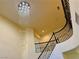 A winding staircase is illuminated by a dazzling chandelier at 2448 Ram Crossing Way, Henderson, NV 89074