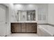 Bathroom featuring double sinks, a large mirror, soaking tub, and plantation shutters for natural light at 2669 Via Monet, Henderson, NV 89044