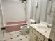 Bathroom showcasing a pink bathtub, toilet, sink with cabinet, and striped accent wall at 2773 Heritage Ct, Las Vegas, NV 89121