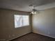Cozy bedroom featuring plush carpeting, natural light from a window, and a ceiling fan at 2773 Heritage Ct, Las Vegas, NV 89121