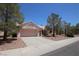 A single-story home is showcased, highlighting its two-car garage and desert landscaping at 2820 Bluff Point Dr, Las Vegas, NV 89134
