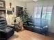 Inviting living room featuring a comfy blue recliner, a black leather couch and lots of natural light at 2820 Bluff Point Dr, Las Vegas, NV 89134