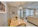 Well-lit dining area with a natural wood table and view of the living room at 2870 Turnstone Ridge St, Henderson, NV 89044