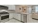 Bright kitchen features stainless appliances, stone counters, and white cabinets at 2870 Turnstone Ridge St, Henderson, NV 89044