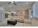 Cozy living room with modern furnishings, flowing into kitchen with white cabinetry, and an open-concept dining area at 2870 Turnstone Ridge St, Henderson, NV 89044