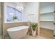 Modern bathroom featuring a soaking tub, gold accents and an open walk-in closet at 3020 Via Venezia, Henderson, NV 89052