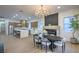 Open floorplan with a dining room featuring an elegant chandelier, fireplace, and kitchen in the background at 3020 Via Venezia, Henderson, NV 89052
