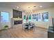 Dining room featuring modern chandelier, large windows offering hillside view, and a sleek fireplace at 3020 Via Venezia, Henderson, NV 89052