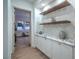 Hallway featuring stylish cabinets with a marble countertop, open shelving, and modern decor at 3020 Via Venezia, Henderson, NV 89052