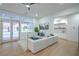 Bright living room with a white sectional, access to the backyard, and a stylish built-in bar area at 3020 Via Venezia, Henderson, NV 89052