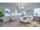 Bright main bedroom showcasing large windows, modern chandelier, hardwood floors, and stylish furnishings at 3020 Via Venezia, Henderson, NV 89052