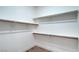 Walk-in closet with multiple shelves and wood-stained hanging bars at 3020 Via Venezia, Henderson, NV 89052