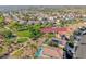 Aerial view of a neighborhood featuring homes with tile roofs, desert landscaping, and a community park at 3050 Whispering Crest Dr, Henderson, NV 89052