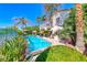 Inviting backyard with a sparkling pool, lush landscaping, and a charming two-story home at 3050 Whispering Crest Dr, Henderson, NV 89052