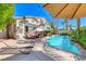 Relaxing backyard features a pool, patio seating, lounge chairs, and lush landscaping at 3050 Whispering Crest Dr, Henderson, NV 89052