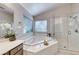 Elegant bathroom featuring a soaking tub, glass shower, and bright natural light at 3050 Whispering Crest Dr, Henderson, NV 89052