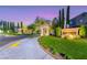 Elegant community entrance with a stone gate, lush landscaping, and well-maintained lawns at 3050 Whispering Crest Dr, Henderson, NV 89052