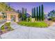 Elegant entrance with manicured lawn, tall trees, and decorative archway, welcoming visitors at 3050 Whispering Crest Dr, Henderson, NV 89052