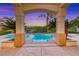 Beautiful swimming pool with a tiled archway and a view of the surrounding landscaping at 3050 Whispering Crest Dr, Henderson, NV 89052
