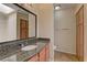 Bathroom featuring granite counters, wood cabinets, updated fixtures, and a shower-tub combo at 3145 E Flamingo Rd # 2080, Las Vegas, NV 89121