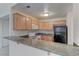The kitchen showcases wooden cabinets, granite countertops, modern appliances, and a breakfast bar at 3145 E Flamingo Rd # 2080, Las Vegas, NV 89121