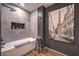 Modern bathroom with a soaking tub, black accent stool, and black and white Paris scenery art piece at 353 E Bonneville Ave # 379, Las Vegas, NV 89101