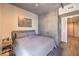 Cozy bedroom with a rustic-chic design, textured concrete accent wall, and wood floors at 353 E Bonneville Ave # 379, Las Vegas, NV 89101