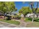Landscaped common area featuring mature trees, winding sidewalk, and well-maintained lawn at 4020 Driscoll Mountain St, Las Vegas, NV 89129