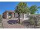 Well-maintained front yard with a mature tree, small seating area, and low-maintenance landscaping at 4020 Driscoll Mountain St, Las Vegas, NV 89129
