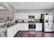 Well-lit kitchen features white cabinets, stainless steel appliances, and hard wood flooring at 4020 Driscoll Mountain St, Las Vegas, NV 89129