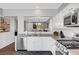 Cozy kitchen showcasing white cabinets, stainless steel appliances, and an open view into the living room at 4020 Driscoll Mountain St, Las Vegas, NV 89129