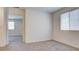 This bedroom features neutral carpet, a window, and an open door at 4229 Venus Falls Ave, North Las Vegas, NV 89084