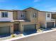 Exterior view showcasing attached townhomes with garages and tidy landscaping at 4229 Venus Falls Ave, North Las Vegas, NV 89084