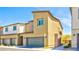 Street view featuring well-maintained townhomes with two-car garages and sidewalks at 4229 Venus Falls Ave, North Las Vegas, NV 89084
