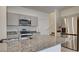 Modern kitchen with granite counters, stainless steel appliances, and gray cabinetry at 4229 Venus Falls Ave, North Las Vegas, NV 89084