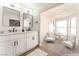 Elegant bathroom featuring double sinks, modern mirrors, and a separate sitting area at 4301 Fortune Ave, Las Vegas, NV 89107
