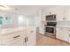 Modern kitchen boasts white cabinets, stainless steel appliances, and an island with a stone countertop at 4301 Fortune Ave, Las Vegas, NV 89107