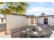 This outdoor patio is staged with a dining set and surrounded by rock and a palm tree at 4301 Fortune Ave, Las Vegas, NV 89107