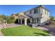 Large backyard with artificial turf, covered patio, privacy landscaping, and exterior architecture at 459 Astillero St, Las Vegas, NV 89138